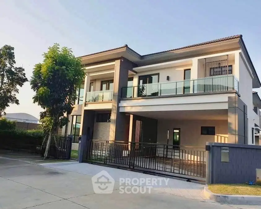 Stunning modern two-story house with glass balcony and spacious driveway in a serene neighborhood.