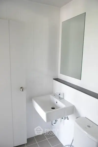 Modern minimalist bathroom with white fixtures and sleek design.