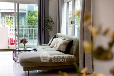 Stylish living room with modern sofa and balcony view, perfect for relaxation and entertaining.