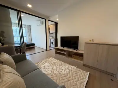 Modern living room with stylish furniture and open layout, featuring a cozy sofa and sleek TV stand.