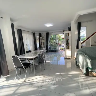 Spacious living room with modern dining area and large windows