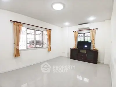 Spacious unfurnished living room with large windows and air conditioning unit.