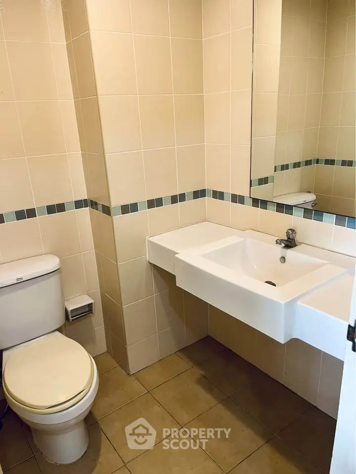 Modern bathroom with sleek sink and tiled walls, perfect for a contemporary home.