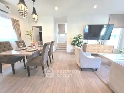 Spacious modern living room with elegant dining area and large TV, perfect for entertaining.