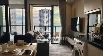 Modern condo with ocean view, open living area, and balcony access, featuring stylish decor and natural light.