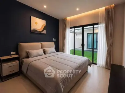 Modern bedroom with large sliding glass doors opening to a private garden, featuring elegant decor and cozy ambiance.