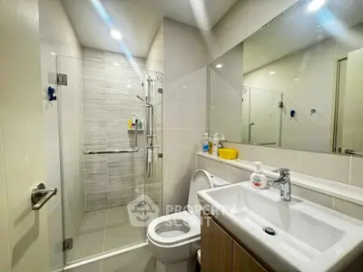 Modern bathroom with glass shower and sleek fixtures in a contemporary home.