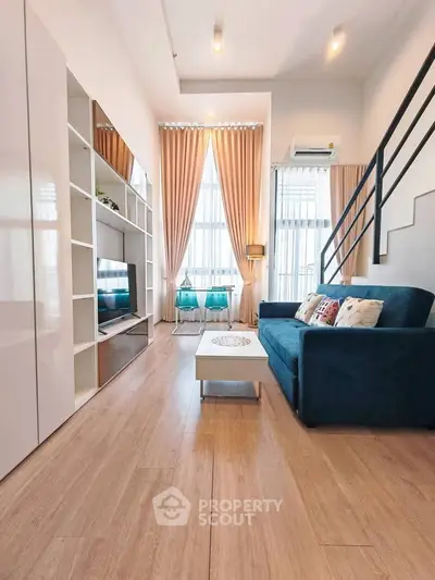Modern living room with high ceilings, elegant curtains, and stylish furniture in a bright, airy space.