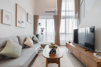Modern living room with high ceilings, stylish decor, and large windows for natural light.
