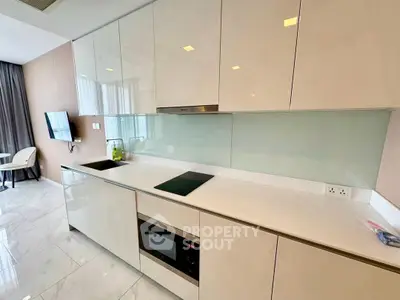 Modern kitchen with sleek white cabinets and built-in appliances in a stylish apartment.