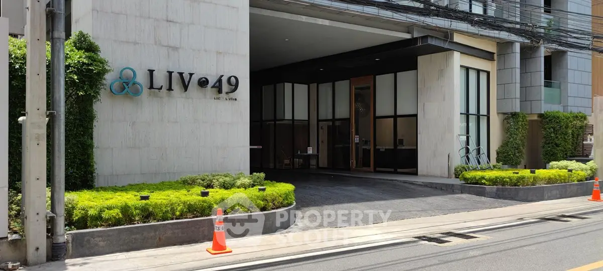 Modern building entrance with lush greenery and sleek design at LIV@49.