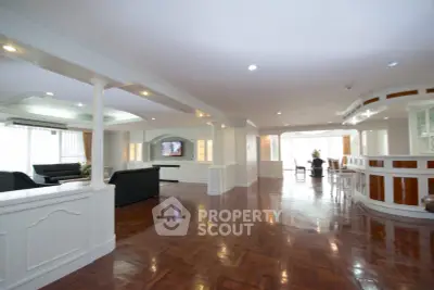 Spacious open-plan living room with elegant wooden flooring and modern furnishings.