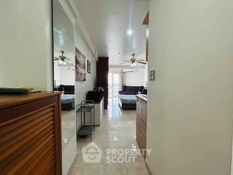 Spacious living area with modern decor and ceiling fan, perfect for relaxation.