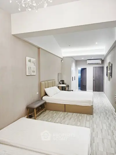 Spacious modern bedroom with two beds and elegant decor in a stylish apartment.