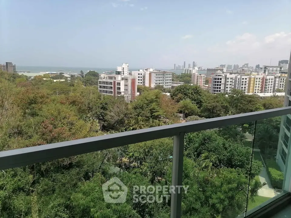 Stunning cityscape view from high-rise balcony overlooking lush greenery and skyline.