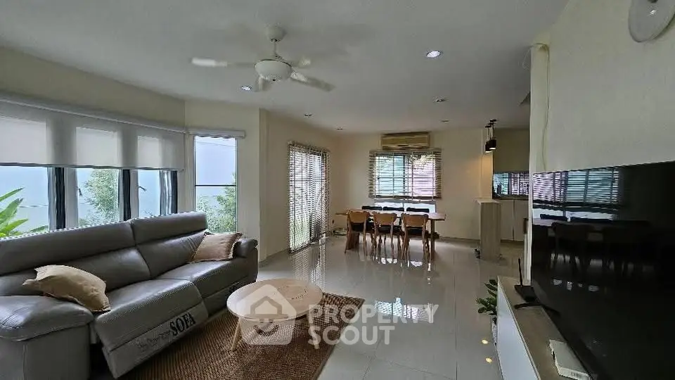 Spacious living room with modern decor and open dining area, perfect for family gatherings.