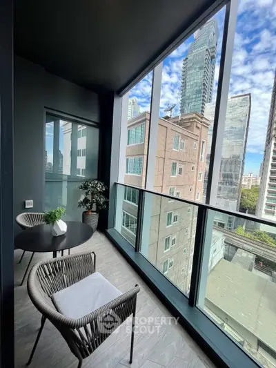Modern balcony with city view, stylish seating, and sleek design in urban high-rise.
