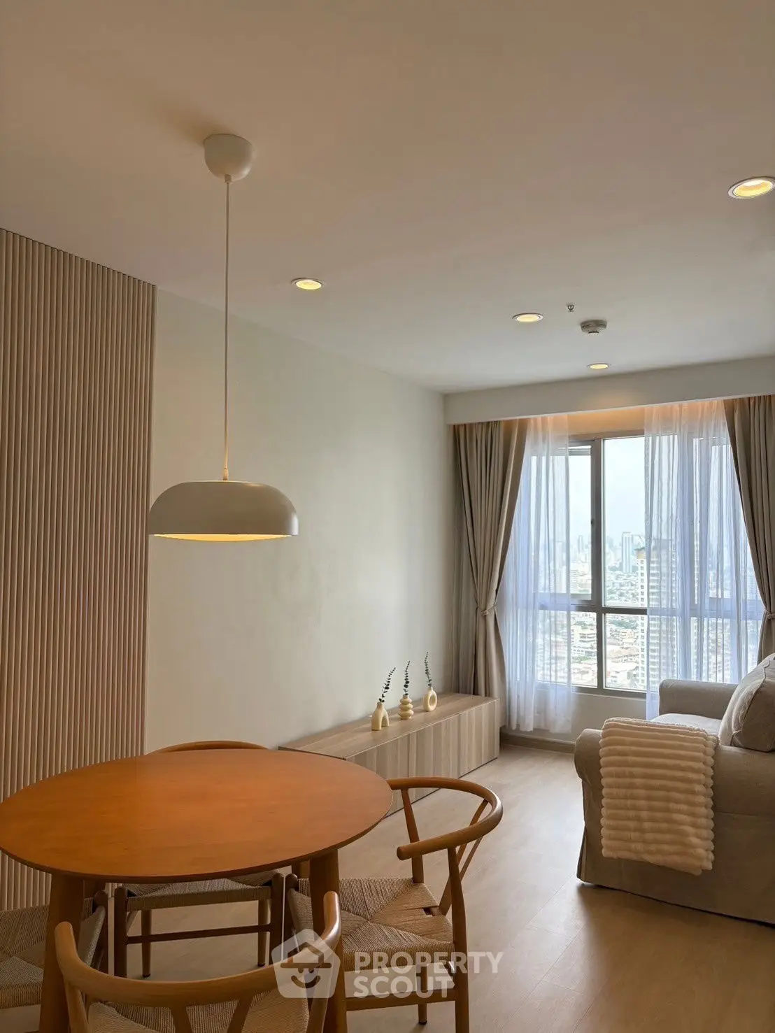 Chic modern living room with city view, cozy seating, and stylish decor.