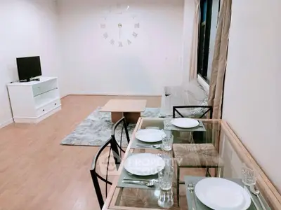 Spacious living room with modern decor and dining area, featuring a wall clock and cozy seating.