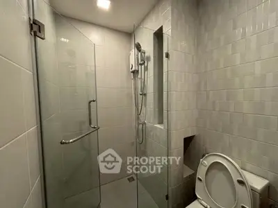 Modern bathroom with glass shower and tiled walls in sleek design