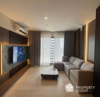 Modern living room with sleek design, large sofa, and wall-mounted TV in a stylish apartment.