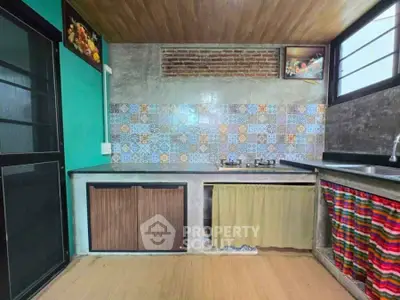 Charming rustic kitchen with colorful tiles and modern gas stove.