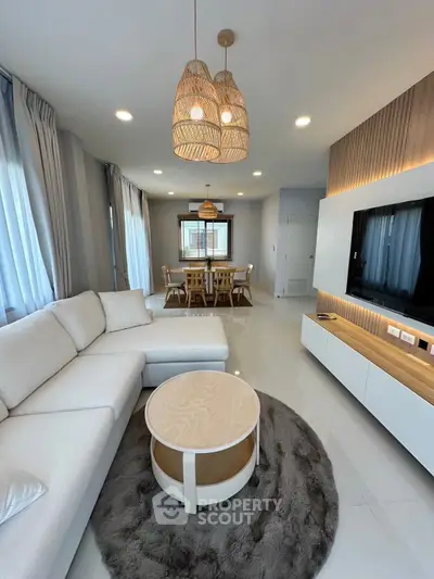 Modern living room with stylish decor and dining area, featuring cozy lighting and elegant furniture.