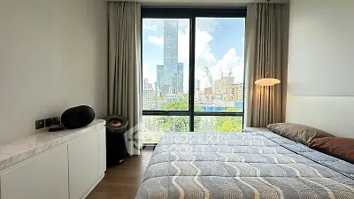 Modern bedroom with large window offering stunning city view and stylish decor.
