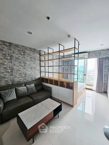 Modern living room with stylish partition and city view, featuring sleek furniture and bright natural light.