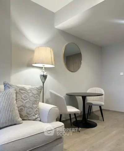 Modern living room with stylish furniture and elegant decor, featuring a cozy seating area and a chic round table.