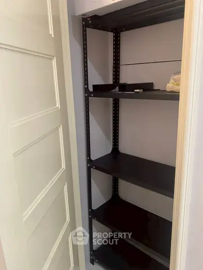 Compact storage space with sturdy black shelving unit in a modern home