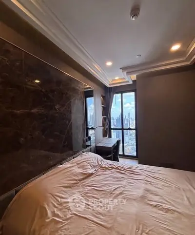 Luxurious bedroom with city view and elegant decor in modern apartment.