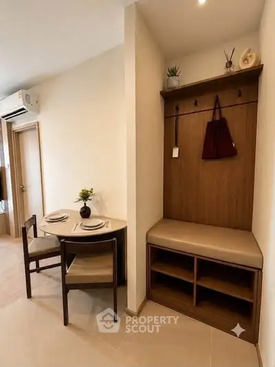 Cozy dining nook with table set for two and stylish entryway bench in modern apartment.