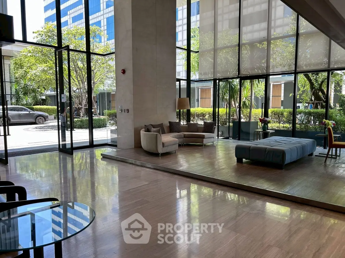 Spacious modern lobby with floor-to-ceiling windows and elegant seating area.