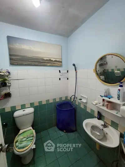 Cozy bathroom with ocean-themed decor and practical amenities in a compact space.