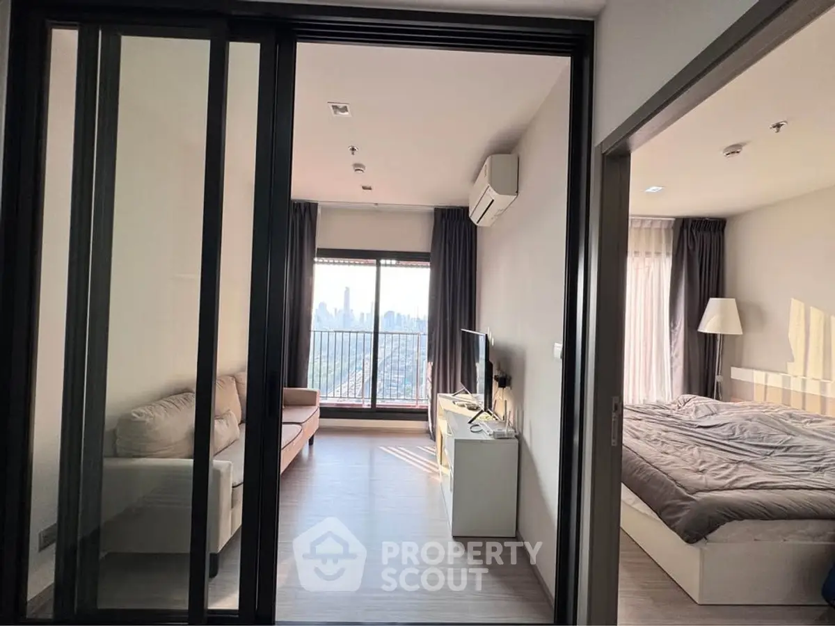 Modern apartment with cozy living room and bedroom, featuring city view and natural light.