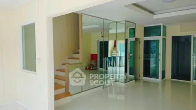 Spacious modern interior with mirrored walls and staircase, ideal for stylish living.
