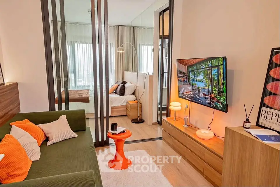 Modern living room with stylish decor and view into cozy bedroom