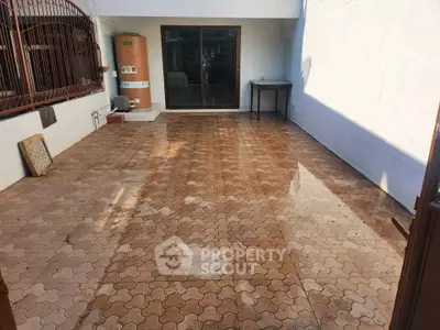 Spacious outdoor patio with tiled flooring and ample sunlight, perfect for gatherings or relaxation.