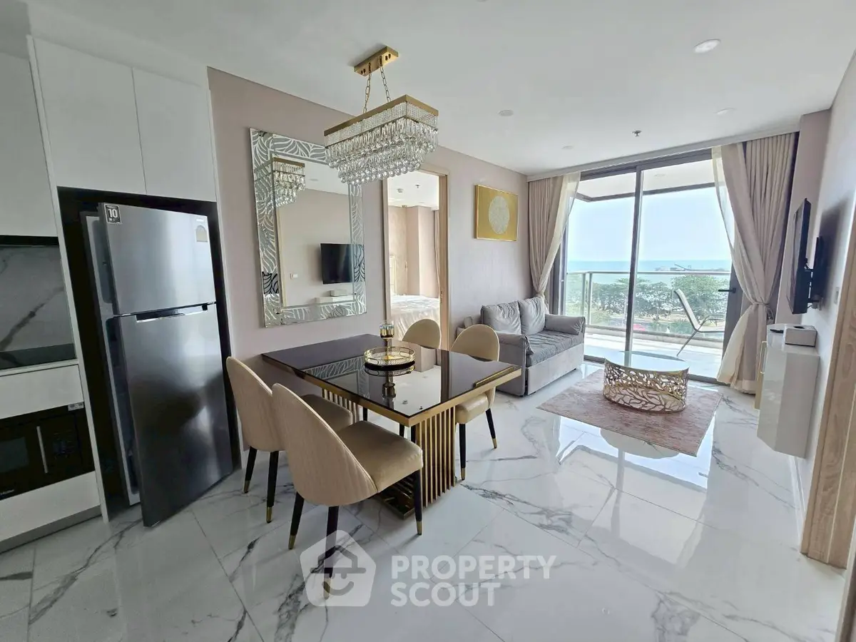 Luxurious open-plan living room with elegant dining area and stunning ocean view balcony.
