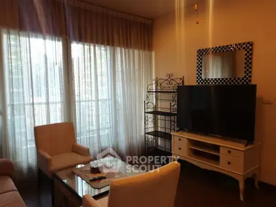 Cozy living room with elegant furniture and large TV, perfect for relaxation.