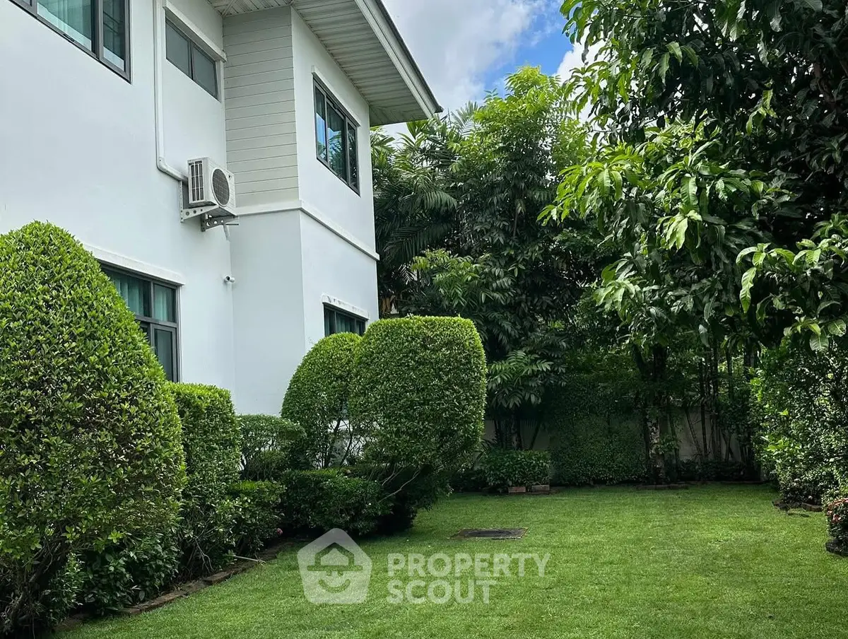 Beautiful garden view of a modern house with lush greenery and manicured lawn.