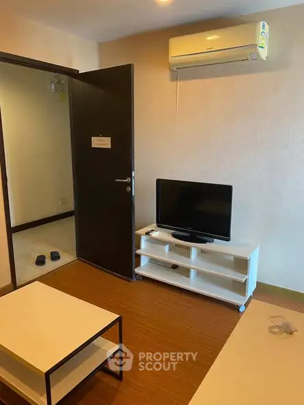 Cozy living room with air conditioning and modern TV setup, perfect for relaxation.