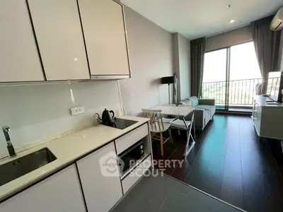 Modern open-layout kitchen and living room with balcony view in stylish apartment