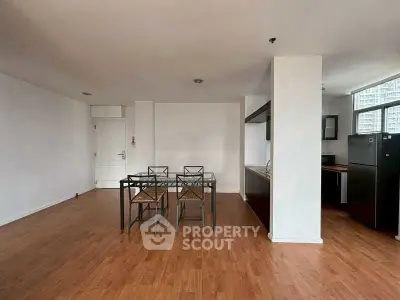 Spacious open-plan living and dining area with modern kitchen and hardwood floors.