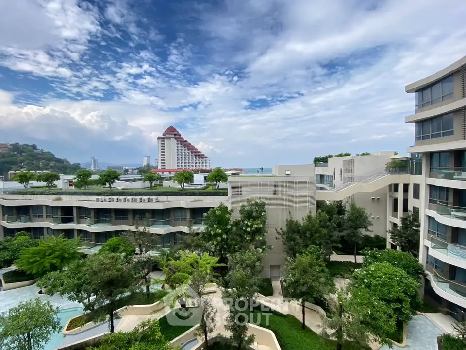 Luxurious modern apartment complex with lush gardens and stunning ocean view
