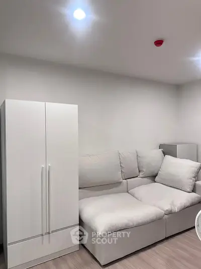 Cozy modern living room with white sofa and wardrobe, perfect for relaxation.
