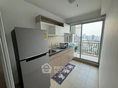 Modern kitchen with appliances and city view from balcony in high-rise apartment.