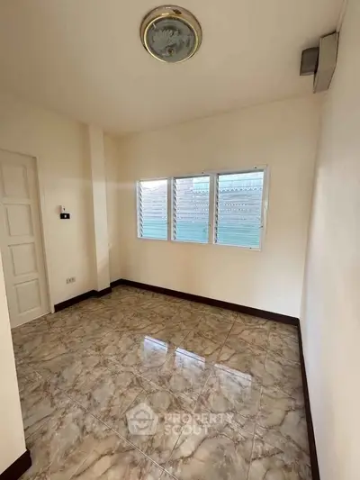 Spacious room with marble flooring and large windows in a modern home.