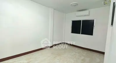 Spacious unfurnished room with air conditioning and large window, ideal for customization.